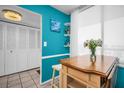 Charming breakfast nook with built-in table, white stools, turquoise walls, and a window with natural light at 7100 Sunset Way # 303, St Pete Beach, FL 33706