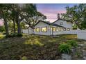 Beautiful renovated two-story home at dusk with modern exterior and a large yard at 7210 8Th N Ave, St Petersburg, FL 33710