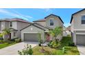 Charming two-story home with a well-manicured lawn, gray exterior, and attached two-car garage at 7331 Canterbury Bells Ct, Tampa, FL 33619