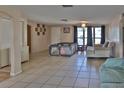 Spacious living room with neutral walls, tile flooring, and ample natural light from a large window at 9836 Rainbow Ln, Port Richey, FL 34668