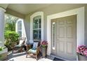Cozy front porch with seating area, stylish door and window trim at 10868 Breaking Rocks Dr, Tampa, FL 33647