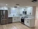 Bright kitchen with white cabinets, stainless steel appliances, and modern fixtures at 11210 Yewtree Ave, Port Richey, FL 34668