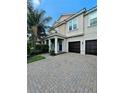Inviting home with a two-car garage, a covered porch with columns, and a beautifully bricked driveway at 11936 Sand Myrtle Rd, Riverview, FL 33579