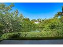 Lush backyard with dense foliage and a serene pond, creating a private and tranquil outdoor space at 208 Villa Dr # 208, Osprey, FL 34229