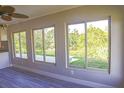 Bright living room featuring new wood flooring and large windows with views of the surrounding greenery at 208 Villa Dr # 208, Osprey, FL 34229