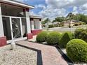 Inviting walkway leading to the front entrance, surrounded by decorative landscaping and manicured bushes at 301 Caloosa Palms Ct, Sun City Center, FL 33573