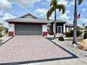 Charming single-story home with a paved driveway, well-manicured lawn, and mature palm trees at 301 Caloosa Palms Ct, Sun City Center, FL 33573