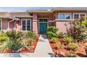 Inviting front entrance with a vibrant blue double door, lush greenery, and mulch landscaping leading to the home at 3136 Sandhill Dr, Holiday, FL 34691