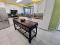 Spacious kitchen with white cabinetry, butcher block countertops, and a versatile kitchen island at 3339 Avanti Cir, North Port, FL 34287