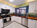 Modern kitchen featuring stainless steel appliances, stylish backsplash, and butcher block countertops at 3339 Avanti Cir, North Port, FL 34287
