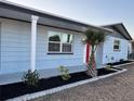 Charming blue home with fresh paint, manicured lawn, tasteful landscaping and mature palm trees at 3615 Kingsbury Dr, Holiday, FL 34691