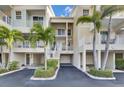 Multiple condos each with a garage and balconies with white railings surrounded by palm trees at 459 Bahia Beach Blvd, Ruskin, FL 33570