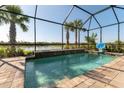 Inviting pool features a waterfall, basketball hoop, and a screened enclosure with views of a tranquil pond at 6223 Baywood Ct, Bradenton, FL 34211