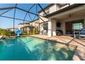Outdoor pool with a basketball hoop and seating area under a screened lanai with lake views at 6223 Baywood Ct, Bradenton, FL 34211
