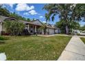 Residential home showcasing a well-maintained front lawn, paved walkway, and a two-car garage at 7850 Lake Placid Ln, New Port Richey, FL 34655
