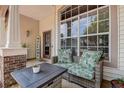 Cozy front porch features wicker seating with plush cushions and a welcoming entrance at 7850 Lake Placid Ln, New Port Richey, FL 34655