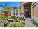 Inviting entrance of this home is framed by lush landscaping and a quaint pond at 10229 Avelar Ridge Dr, Riverview, FL 33578