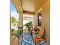 Inviting front porch with comfortable seating and a decorative blue patterned rug, creating a cozy outdoor space at 10017 Victory Gallop Loop, Ruskin, FL 33573