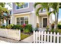 Inviting home entrance with a picket fence, lush landscaping, and a walkway leading to the front door with a Ring doorbell at 11309 Grand Park Ave, Riverview, FL 33578
