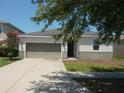 Inviting single-story home with a driveway, two-car garage, and beautiful landscaping at 11527 Southern Creek Dr, Gibsonton, FL 33534