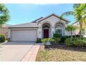 Well maintained single-story home featuring a lush lawn, mature landscaping and modern architectural details at 12310 Streambed Dr, Riverview, FL 33579