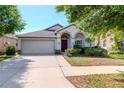 Charming single-story home with a well-manicured lawn and a welcoming facade at 12310 Streambed Dr, Riverview, FL 33579