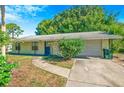 Charming single-story home featuring a well-maintained lawn and a one-car garage at 1424 Castleworks Ln, Tarpon Springs, FL 34689