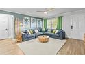 Inviting living room featuring a large sectional sofa, area rug, and surfboard decoration at 1596 Idle Dr, Clearwater, FL 33756