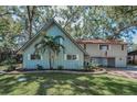 Well-maintained two-story home with lush landscaping, including a mature palm tree and flowering bushes at 16019 Chastain Rd, Odessa, FL 33556