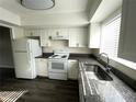 White kitchen features granite countertops, modern appliances, and plenty of cabinet space at 1610 58Th S Ave # 6, St Petersburg, FL 33712