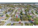 Aerial view showcasing the home with a private pool surrounded by lush greenery in a residential neighborhood at 2217 Stacy Ct, Dunedin, FL 34698