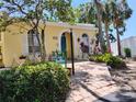 Charming home featuring a bright blue door, arched entryway, and lush tropical landscaping at 2512 W Texas Ave # C, Tampa, FL 33629