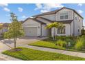 Attractive home featuring a paved driveway, lush landscaping, and a well-maintained lawn at 2577 Buckthorn Loop, North Port, FL 34289