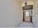 Inviting entrance with textured walls, tiled floor, and elegant lighting fixture above front door at 322 Northway Dr, Sun City Center, FL 33573
