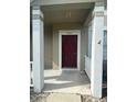 A covered porch reveals a solid red front door with sidelight, enhancing the entry's appeal at 3441 Santa Rita Lane, Land O Lakes, FL 34639