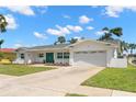 A well-maintained lawn and landscaping frames this lovely white house with a two-car garage at 3945 Versailles Dr, Tampa, FL 33634