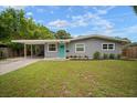 Inviting exterior with well-manicured lawn, carport, and bright, colorful door adding a pop of charm to the home at 5115 32Nd N Ave, St Petersburg, FL 33710