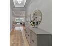 Inviting hallway featuring a decorative mirror, chandelier, and an open view to the living room at 5313 Windy Grove Dr, Wimauma, FL 33598