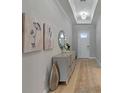 Elegant hallway with a console table, decorative mirror, and a chandelier at 5313 Windy Grove Dr, Wimauma, FL 33598