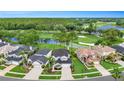 Stunning aerial view of homes overlooking a lush golf course with scenic water features and verdant trees at 5403 Avenal Dr, Lutz, FL 33558