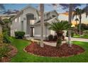 Charming two-story home featuring a landscaped yard with beautiful plants and green grass at 5403 Avenal Dr, Lutz, FL 33558