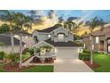 Beautiful two-story home featuring a well-manicured lawn, mature palm trees, and a pristine garage at 5403 Avenal Dr, Lutz, FL 33558