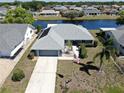 Beautiful waterfront home featuring solar panels, a two-car garage, and well-maintained landscaping at 613 Fort Duquesna Dr, Sun City Center, FL 33573