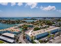 Aerial view of the condo building featuring a pool, convenient parking, and a beautiful waterfront setting at 6161 Gulf Winds Dr # 338, St Pete Beach, FL 33706