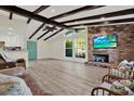 Bright living room with vaulted ceilings, wood beams, a brick fireplace, and lots of natural light at 9107 Bay Ne St, St Petersburg, FL 33702