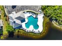 Aerial view showcasing the uniquely shaped community pool with plenty of lounge seating near a small lake at 9516 Amberdale Ct # 202, Riverview, FL 33569