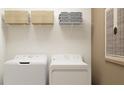 Functional laundry area with modern appliances, storage shelves, and neutral decor at 10194 Gentle Rain Dr, Land O Lakes, FL 34638