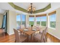 Well-lit dining room with hardwood floors, a stylish chandelier, and large windows offering picturesque views at 10851 Mangrove Cay Ne Ln # 714, St Petersburg, FL 33716