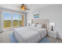 Cozy main bedroom with a tufted headboard, balcony access, and serene views, perfect for relaxation at 10851 Mangrove Cay Ne Ln # 714, St Petersburg, FL 33716