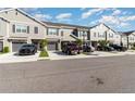 Townhomes boast a classic look, gray siding, dark shutters, driveways, and blue sky above at 10924 Brightleaf Ct, Riverview, FL 33569